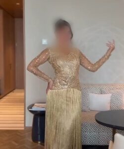 فستان سهرة ذهبي بتطريز لامع وأكمام شفافة مع شراشيب طويلة